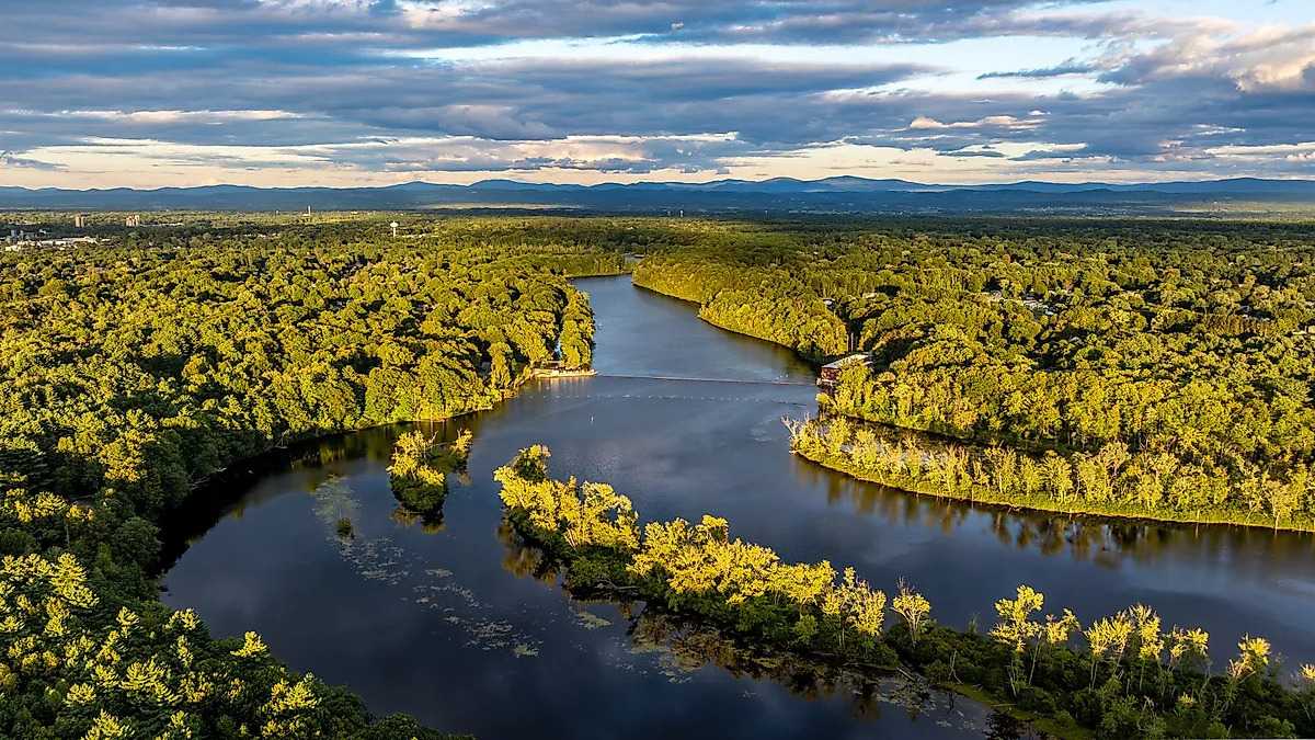 Aerial view of the Orinoco River winding through dense green forest beneath a cloudy sky.
